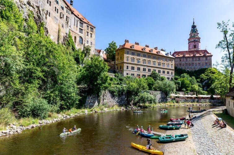 Radeau flottant sur la rivière Vltava avec la tour du château de Český Krumlov en arrière-plan, République Tchèque