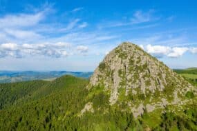 Randonneur avec un bébé en porte-bébé profitant de la vue au sommet du Mont Gerbier de Jonc en Ardèche, France