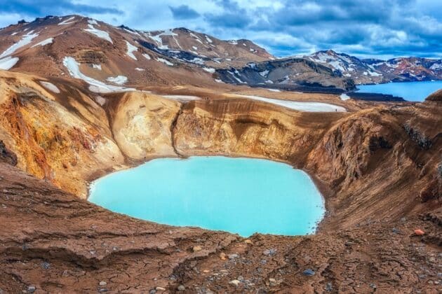 Vue aérienne du cratère du volcan Hverfjall en Islande, montrant ses parois abruptes et son fond sablonneux