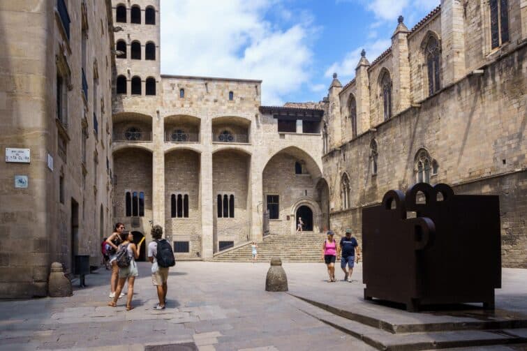 Vue de la Plaza del Rey à Barcelone, montrant des bâtiments historiques et des visiteurs en journée