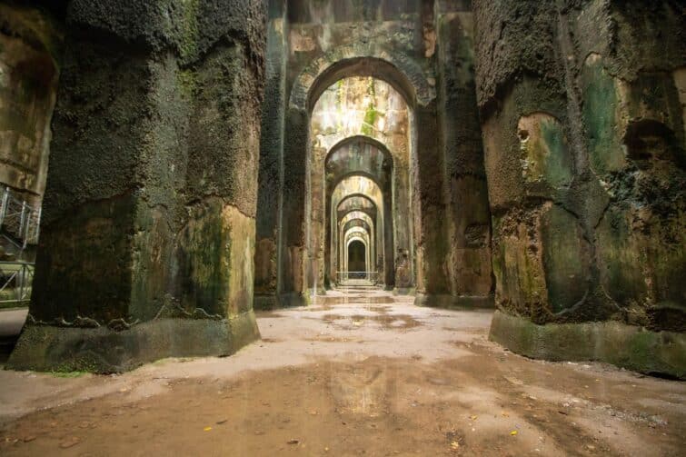 Vue intérieure de la Piscina Mirabilis à Naples, montrant des colonnes et des arches en pierre dans un ancien réservoir d'eau romain