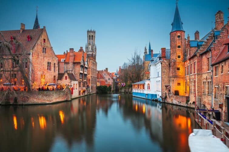 Vue nocturne de Rozenhoedkaai à Bruges avec des lumières reflétant sur l'eau