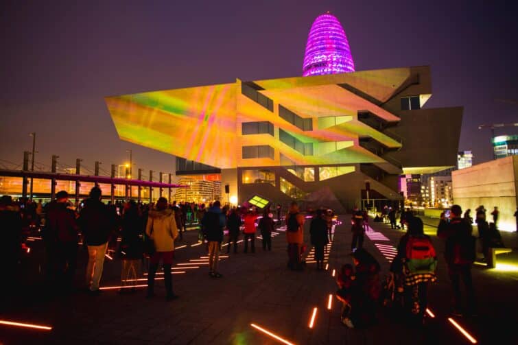 Vue nocturne éclairée de Poblenou, Barcelone, montrant des rues animées et l'architecture moderne