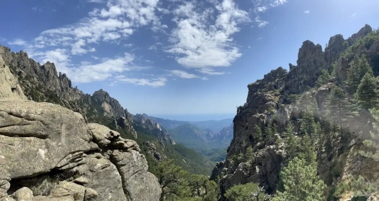 Vue panoramique de Bocca di u Pargulu avec ciel dégagé et montagnes verdoyantes