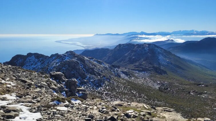 Vue panoramique depuis le sommet du Monte Stello, montrant des sentiers et un paysage montagneux