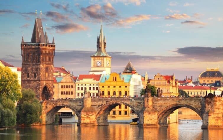 Vue panoramique du Pont Charles de Prague, République tchèque, avec des statues historiques et une vue sur le fleuve Vltava lors d'une journée ensoleillée.