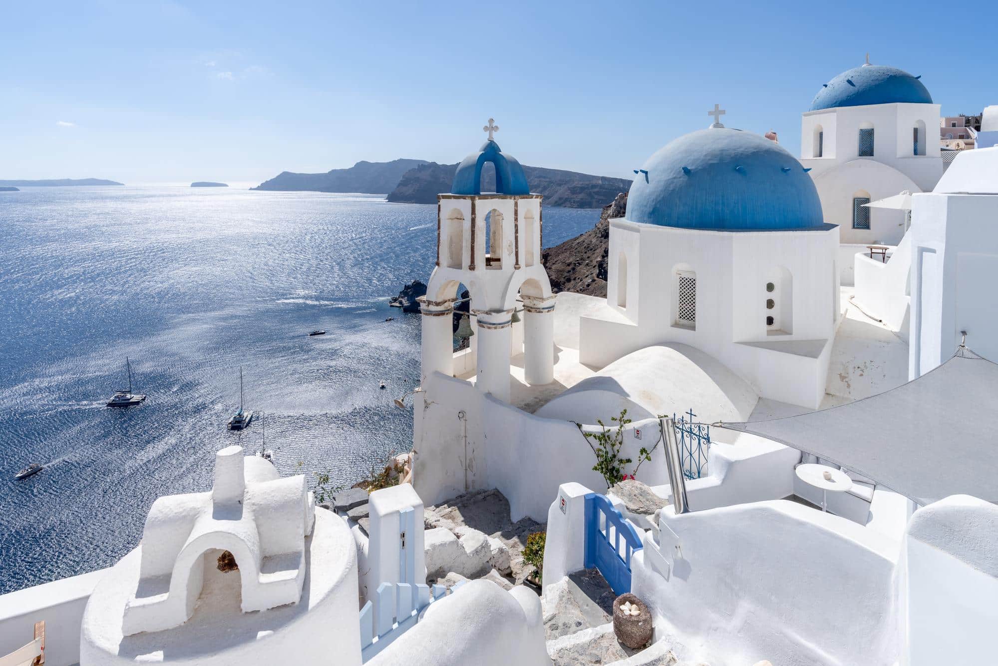Vue pittoresque d'Oia à Santorin en Grèce lors d'une journée ensoleillée avec des maisons blanches et des dômes bleus