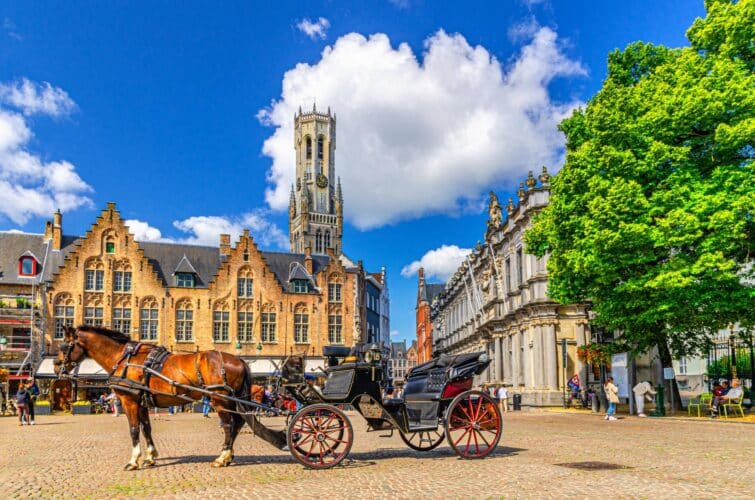 calèche tirée par des chevaux sur des pavés à Bruges