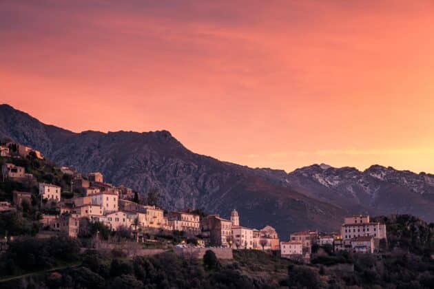 Coucher de soleil sur le village ancien de Belgodère en Corse, avec vue sur la mer et montagnes environnantes