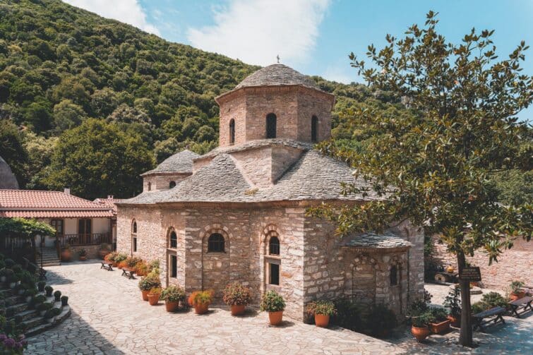 Monastère d'Evangelistria à Skiathos, ancien monastère avec des bâtiments en pierre et des toits rouges entourés de verdure