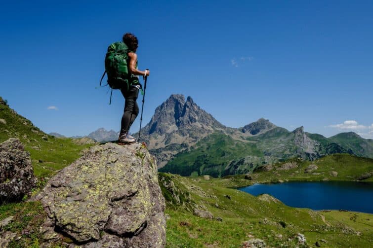 Randonneur contemplant le panorama des Lacs d'Ayous dans les Pyrénées lors du Tour de l'Ossau