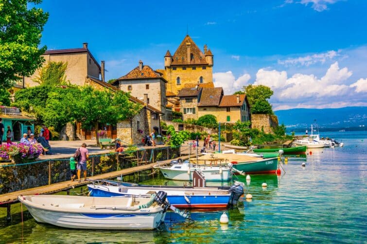 Vue pittoresque du village médiéval d'Yvoire au bord du lac Léman avec des bateaux et des fleurs, en France