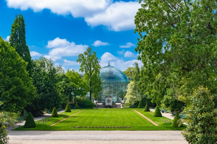 Jardin public des serres d'Auteuil à Paris, avec sentiers verdoyants et architectures en verre