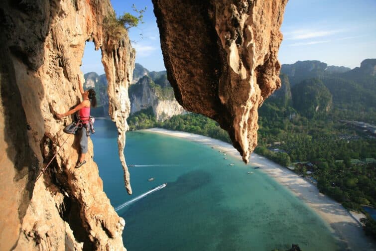 Alpiniste professionnelle escaladant une falaise à Railay Beach, Thaïlande