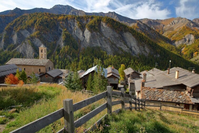 Église de Saint-Véran et maisons traditionnelles avec montagnes en arrière-plan