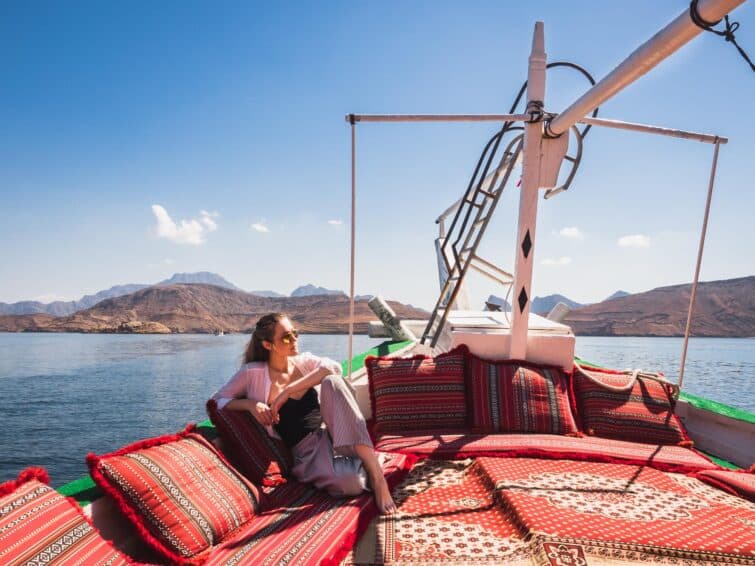 Femme élégante assise sur une couverture rouge en plein air