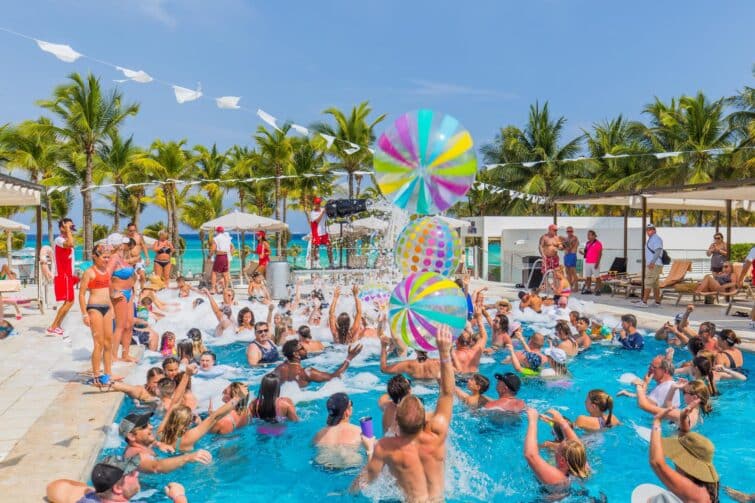 Pool party animée à Cancun, Mexique, avec jeunes adultes dansant près de la piscine