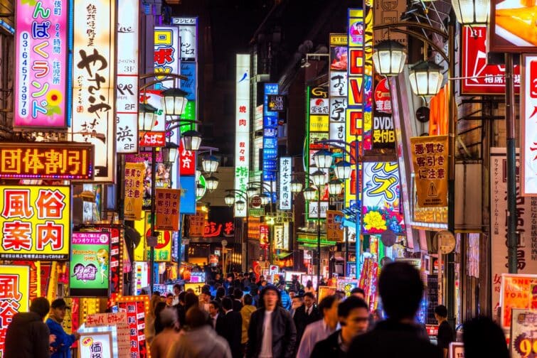 Rue de Tokyo illuminée la nuit avec des enseignes lumineuses à Shinjuku