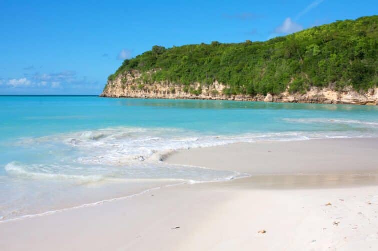 Vue de Dickenson Bay à Antigua-et-Barbuda, avec plage de sable blanc et eau turquoise