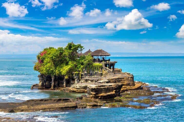 Vue panoramique du temple de Tanah Lot à Bali au coucher du soleil avec l'océan autour