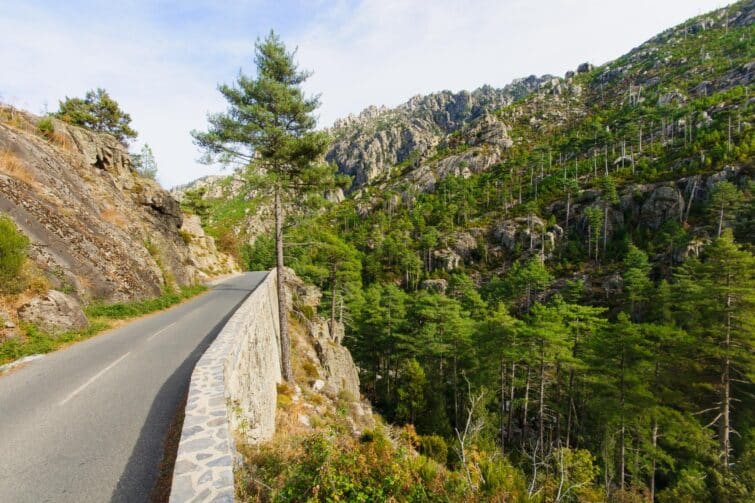 Vue panoramique sur les Gorges de la Restonica en Corse, route sinueuse avec paysage montagneux et rivières claires