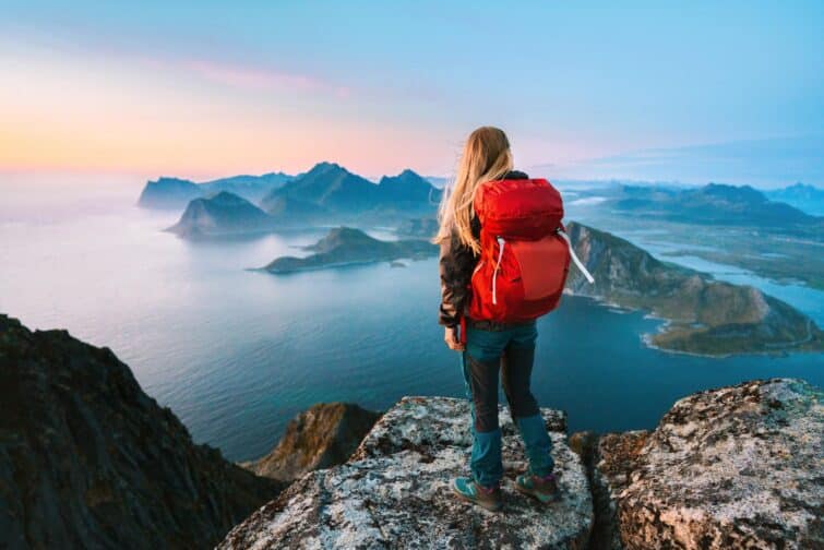 femme avec sac à dos voyageant seule en montagne