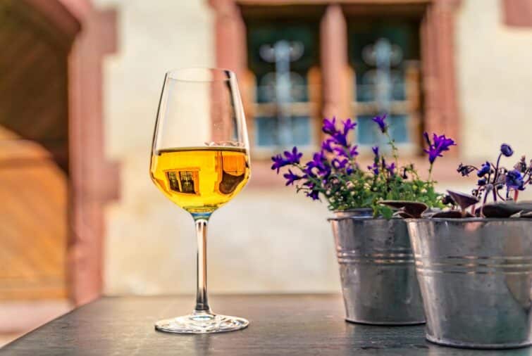 Verre de vin blanc local sur une table de restaurant en plein air à Riquewihr, paradis vinicole