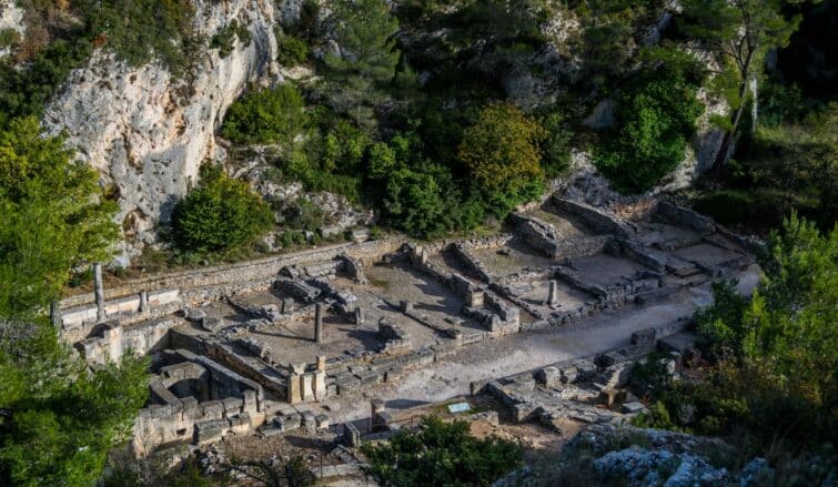 Vue des ruines de l'ancienne ville romaine de Glanum en France, avec focus sur le bouleutérion qui marque l'influence grecque