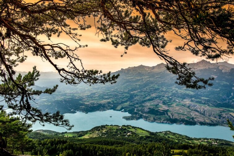 Lac de Serre-Ponçon en hiver avec montagnes enneigées et ciel bleu