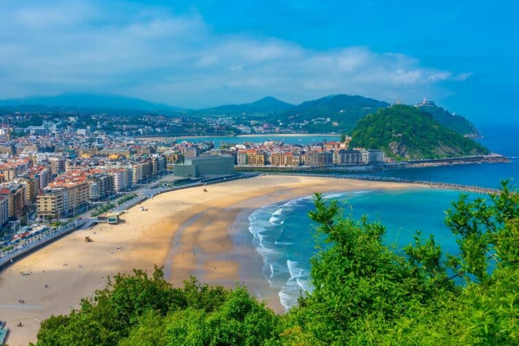 Plage de Zurriola à San Sebastián, Espagne, avec vue sur l'océan et les surfeurs