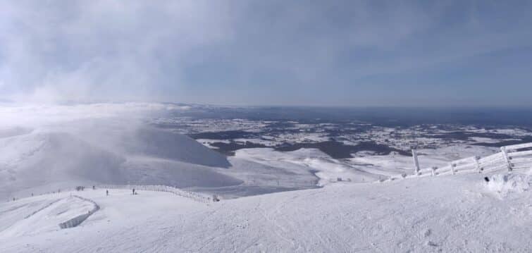 Vue du domaine skiable de Super Besse avec des skieurs et des montagnes en arrière-plan