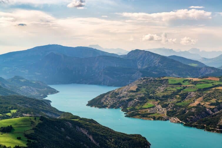 Vue panoramique sur le Lac de Serre-Ponçon avec des eaux bleu turquoise et montagnes en arrière-plan