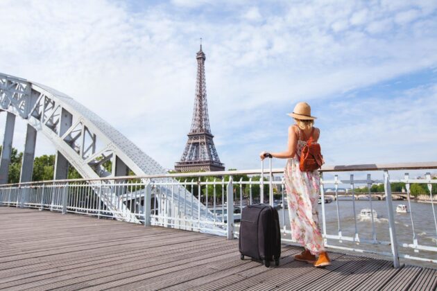 Femme touristique avec valise sortant de l'aéroport pour explorer Paris