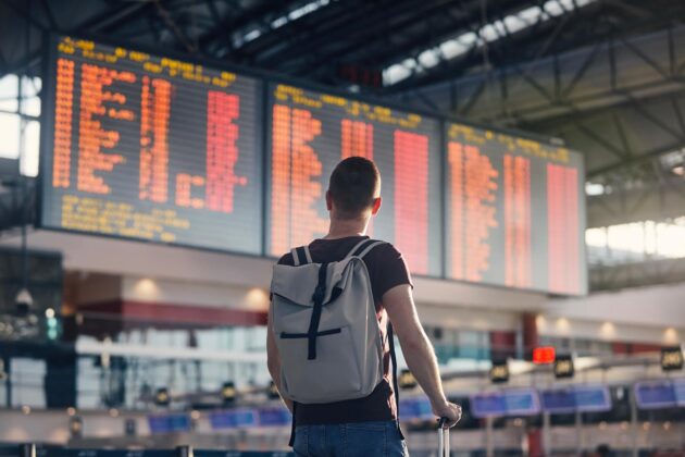 Homme avec sac à dos marchant dans un aéroport, symbolisant la possibilité d'indemnisation pour les voyageurs aériens