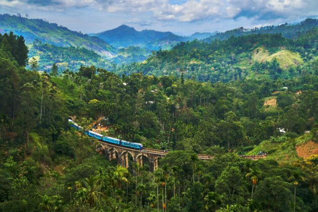 Train voyageant à côté de formations rocheuses rouges dans les Rocheuses américaines