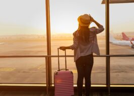 touriste heureux avec sac à dos attendant son vol à l'aéroport
