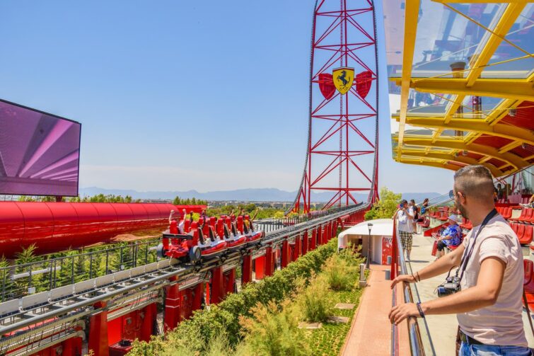 Attraction Red Force à PortAventura World, Espagne, montrant un grand huit rouge et blanc avec des visiteurs profitant de la vitesse.