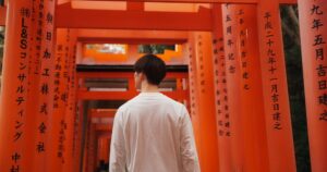 Homme devant un torii au Japon, symbole de la culture japonaise