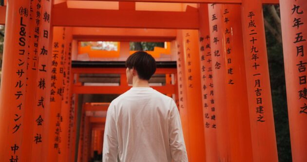 Homme devant un torii au Japon, symbole de la culture japonaise