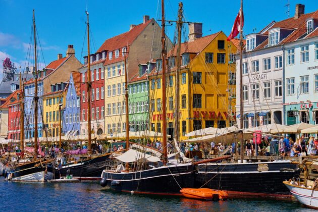 Le port de Nyhavn à Copenhague, célèbre destination touristique, avec des bâtiments historiques colorés et des bateaux sur le front de mer