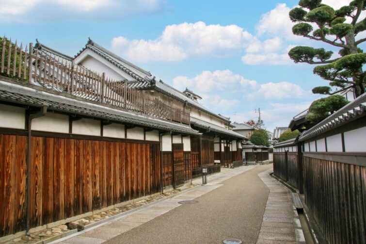 Maisons en bois anciennes le long d'une route étroite à Tondabayashi Templetown
