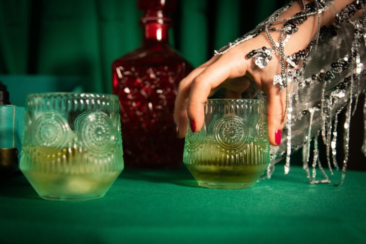 Scène de bar teintée de vert avec bouteille de whisky rouge et verres, Bar Le Moloko, Toulouse, France