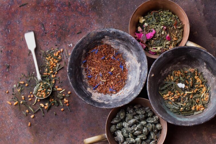 Thé vert et rooibos dans des tasses vintage chinoises sur fond en bois