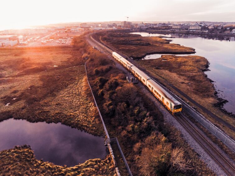 Train irlandais traditionnel jaune et vert se dirigeant vers Galway au coucher de soleil