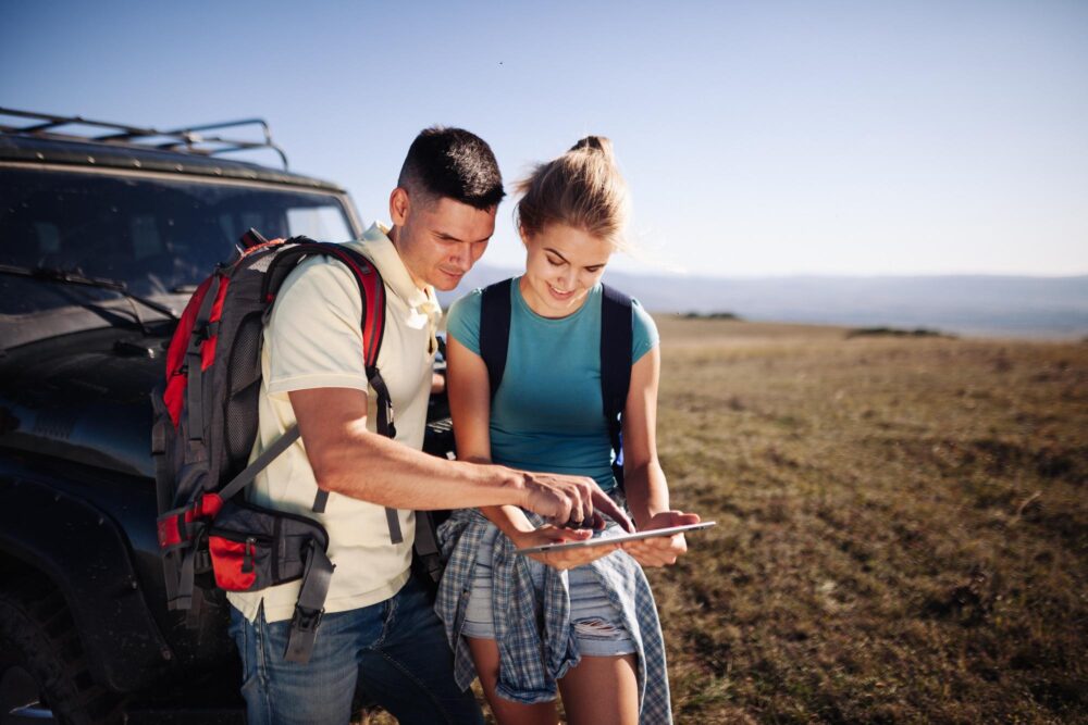 Couple de randonneurs consultant l'application Alltrails sur une tablette
