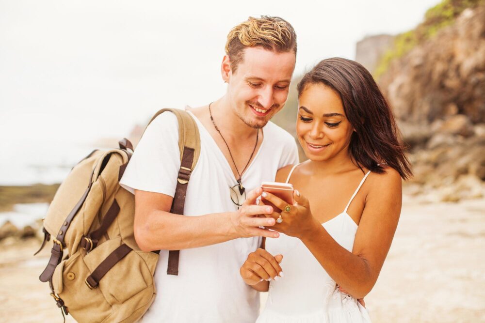 Couple utilisant son téléphone sur une plage en Indonésie