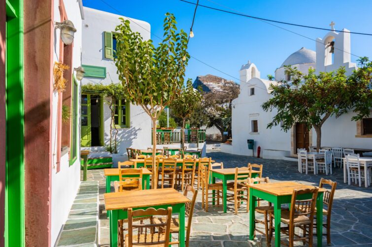Église blanche typique avec taverne sur l'île de Folegandros, représentant la richesse culturelle et gastronomique
