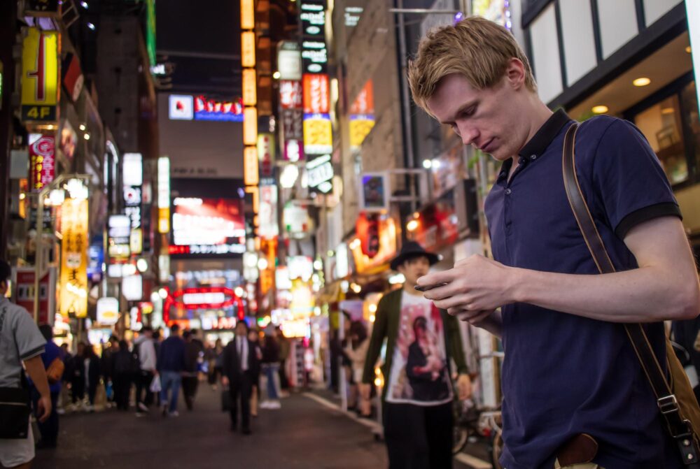 Homme utilisant son téléphone dans une rue de Tokyo