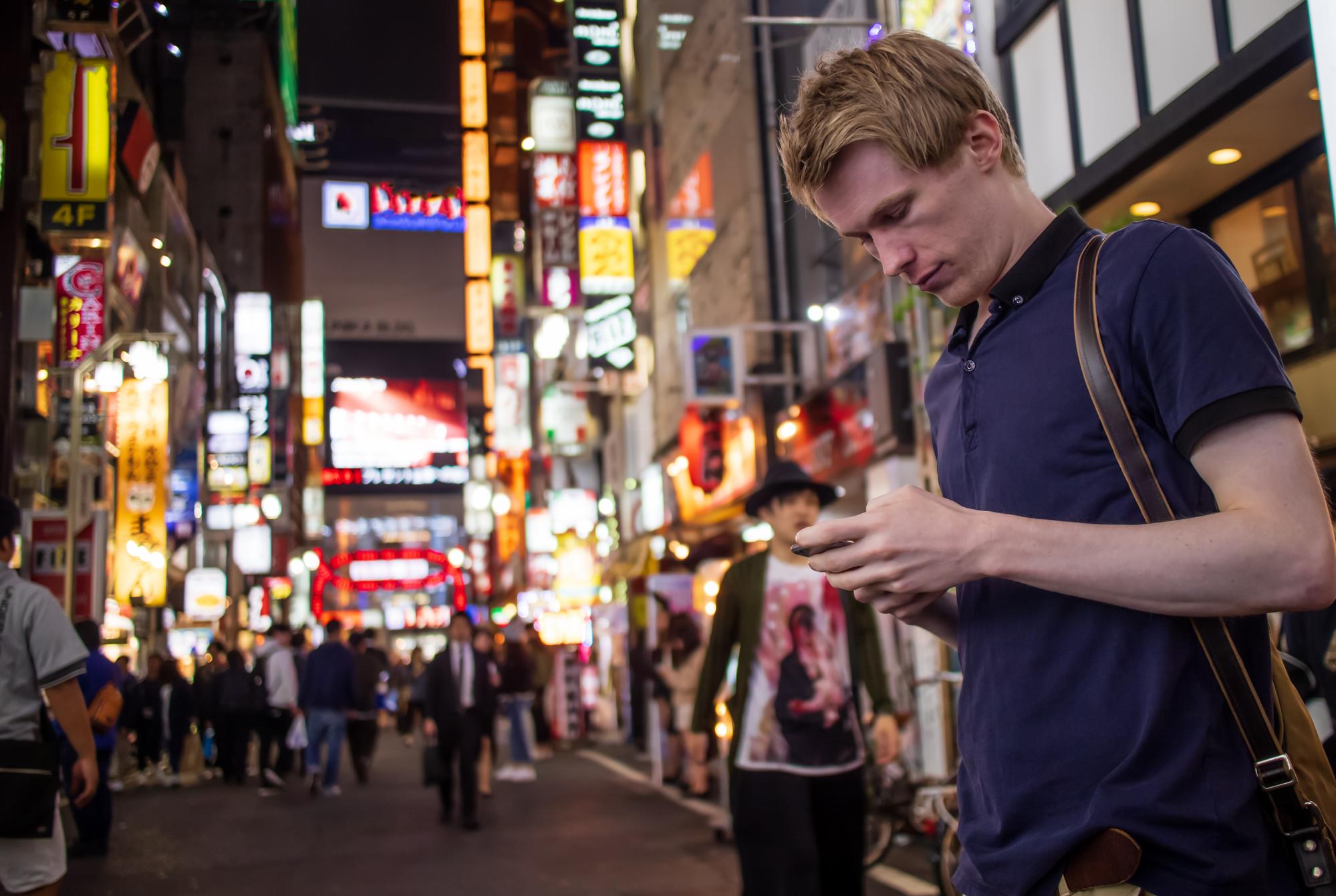 Homme utilisant son téléphone dans une rue de Tokyo