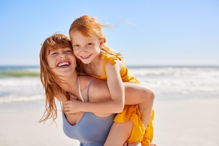 Jeune mère et sa fille s'amusant à la plage